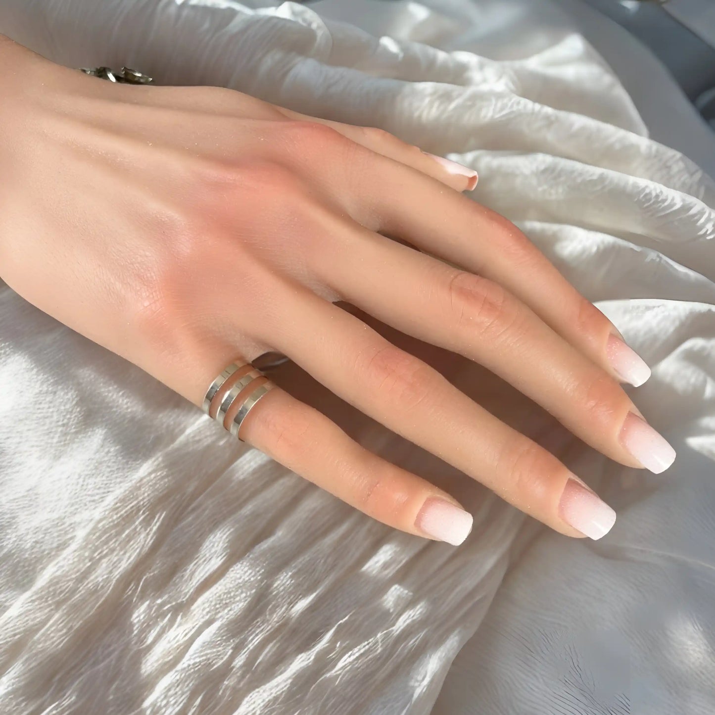 Manucure babyboomer madame nails sur un tissu blanc